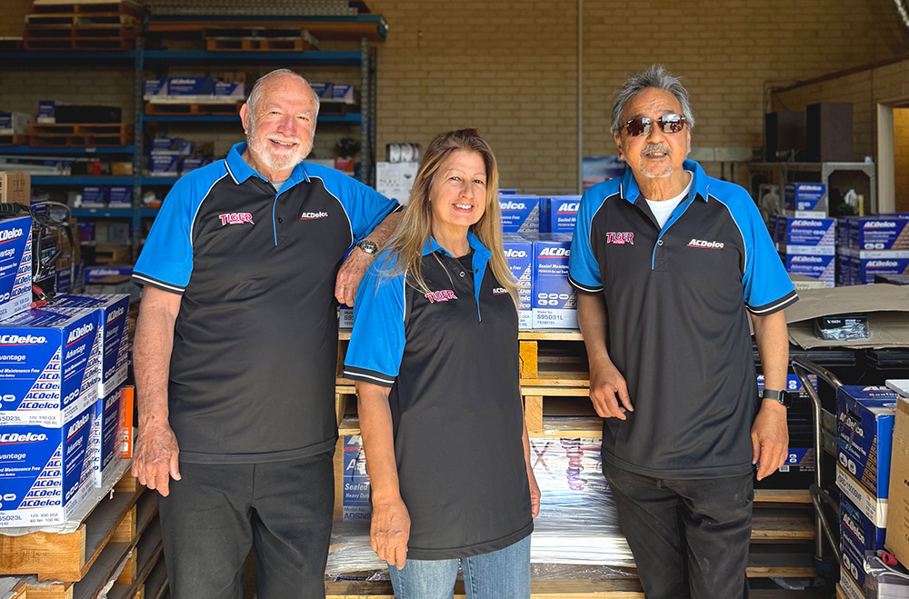 The Tiger Batteries team in the Welshpool workshop, standing in front of ACDelco battery stock